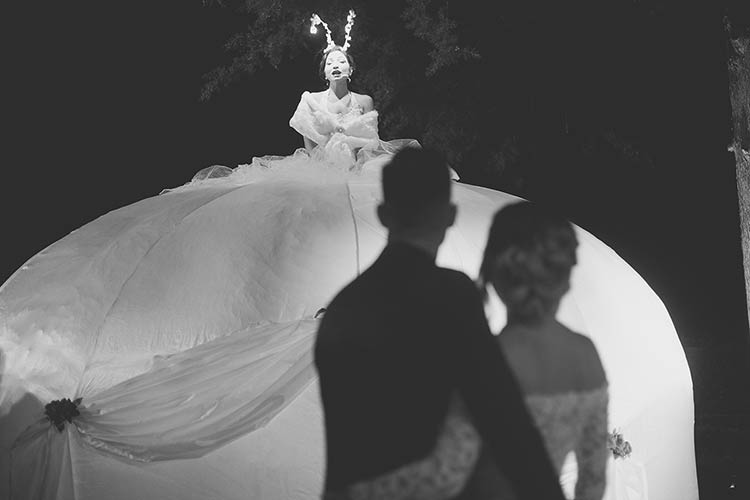 lady dressed in white welcomed the guests and newlyweds