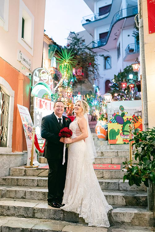 Bride and groom posing on a colorful staircase in Taormina’s historic center during their romantic wedding photoshoot in Sicily.
