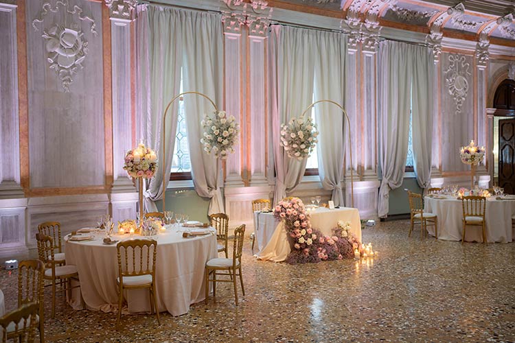 Elegant wedding reception setup in a Venetian palace with florals and candlelight