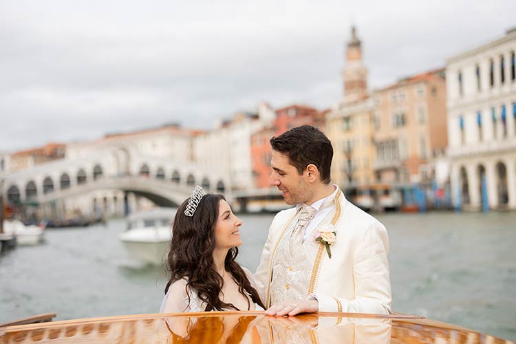 Bride and groom sharing a quiet moment on a boat ride with the Rialto Bridge in the background