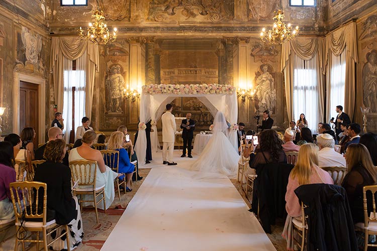 Interfaith wedding in Venice with Jewish traditions under the chuppah inside a historic palace
