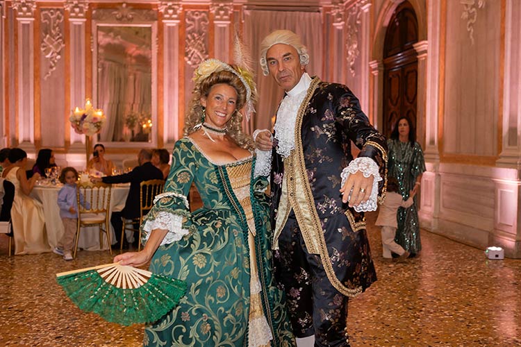 Dancers in elegant 18th-century Venetian costumes entertaining guests during the wedding reception.