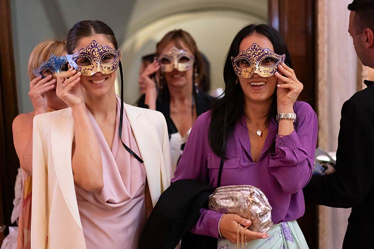 Guests putting on handcrafted Venetian masks as a surprise detail of the wedding celebration.