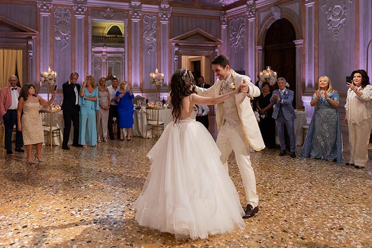 Bride and groom lifted on chairs during the traditional Jewish Hora dance at their Venice wedding.