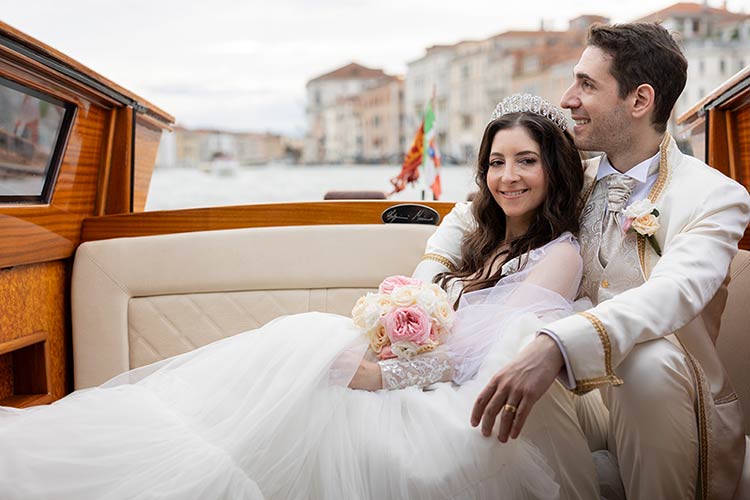 Bride and groom relaxing on a Venetian boat after their destination wedding