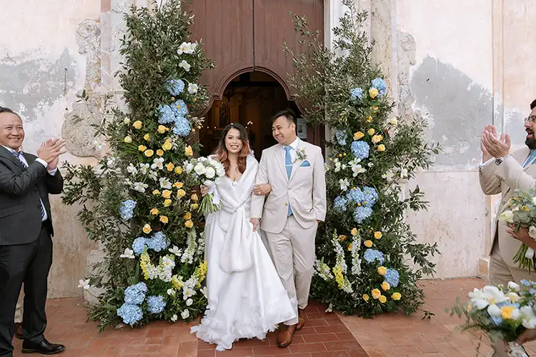 Newlyweds leaving the church surrounded by floral decorations in Taormina