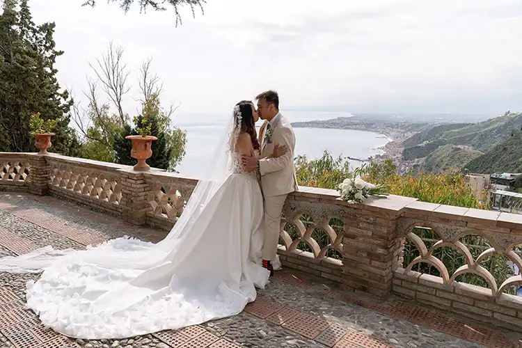 Bride and groom embracing with sea view in Taormina during a winter wedding