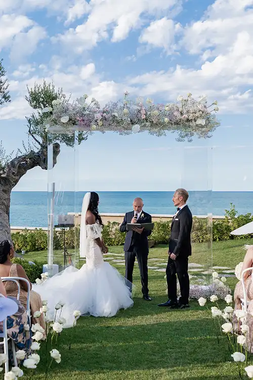 Outdoor wedding ceremony at Villa Estea in Abruzzo with floral arch and Adriatic Sea backdrop