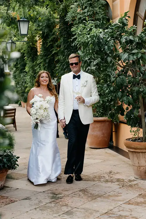 Bride and groom walking through the gardens in Paraggi