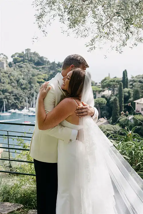 Bride and groom embracing above the Portofino coastline