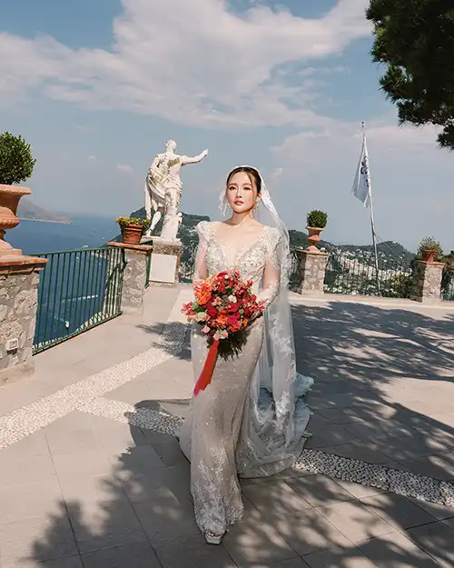 Bride holding a colourful bouquet overlooking the sea in Capri