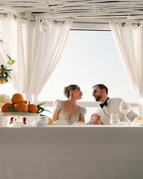 Bride and groom seated at their reception table in Capri