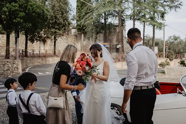 Wedding planner Carola welcoming the bride before the Roman Catholic ceremony in Garlenda