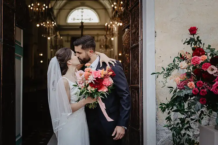 Newlyweds leaving the church surrounded by family and friends in Garlenda
