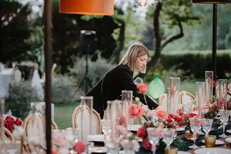 Wedding planner adding the final styling touches before the outdoor reception begins in Liguria