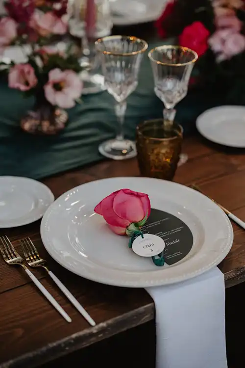 Elegant wedding place setting featuring a single rose and personalised name card at a Ligurian garden reception