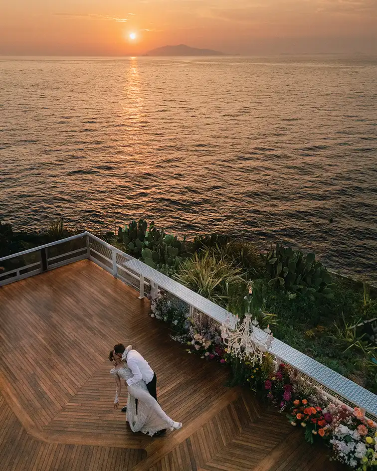 isw_Amalfi-Coast-wedding Bride and groom kissing at sunset overlooking the Mediterranean Sea on the Amalfi Coast